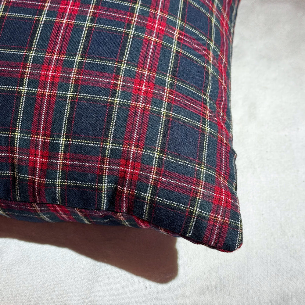 Plaid fabric pillow on a white surface