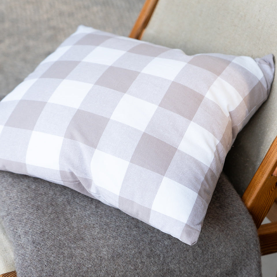 beige gingham cushion on a beige merino wool throw