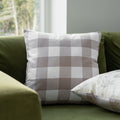 beige gingham cushion on a green sofa