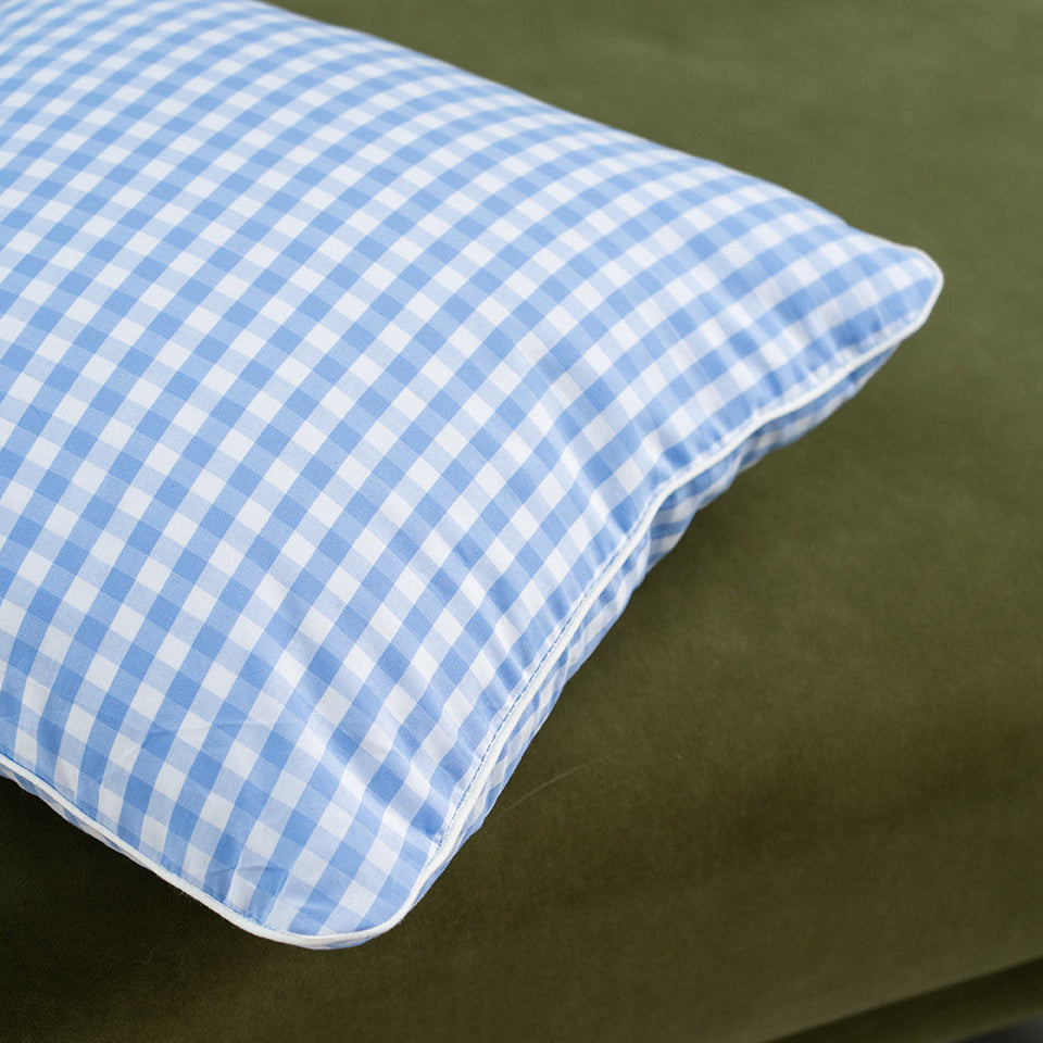 blue gingham cushion on a green sofa