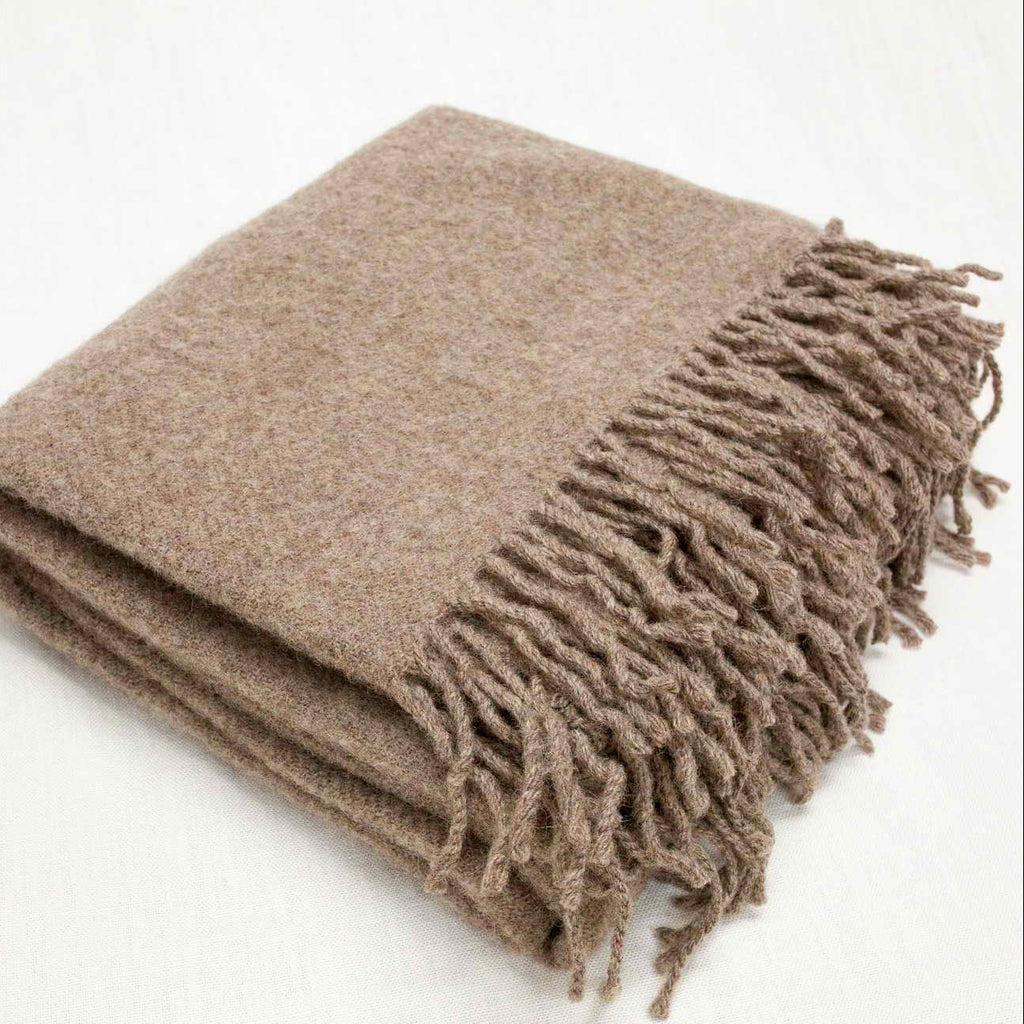Beige blanket with fringes on a white background
