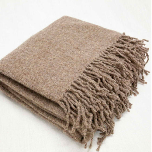 Beige blanket with fringes on a white background