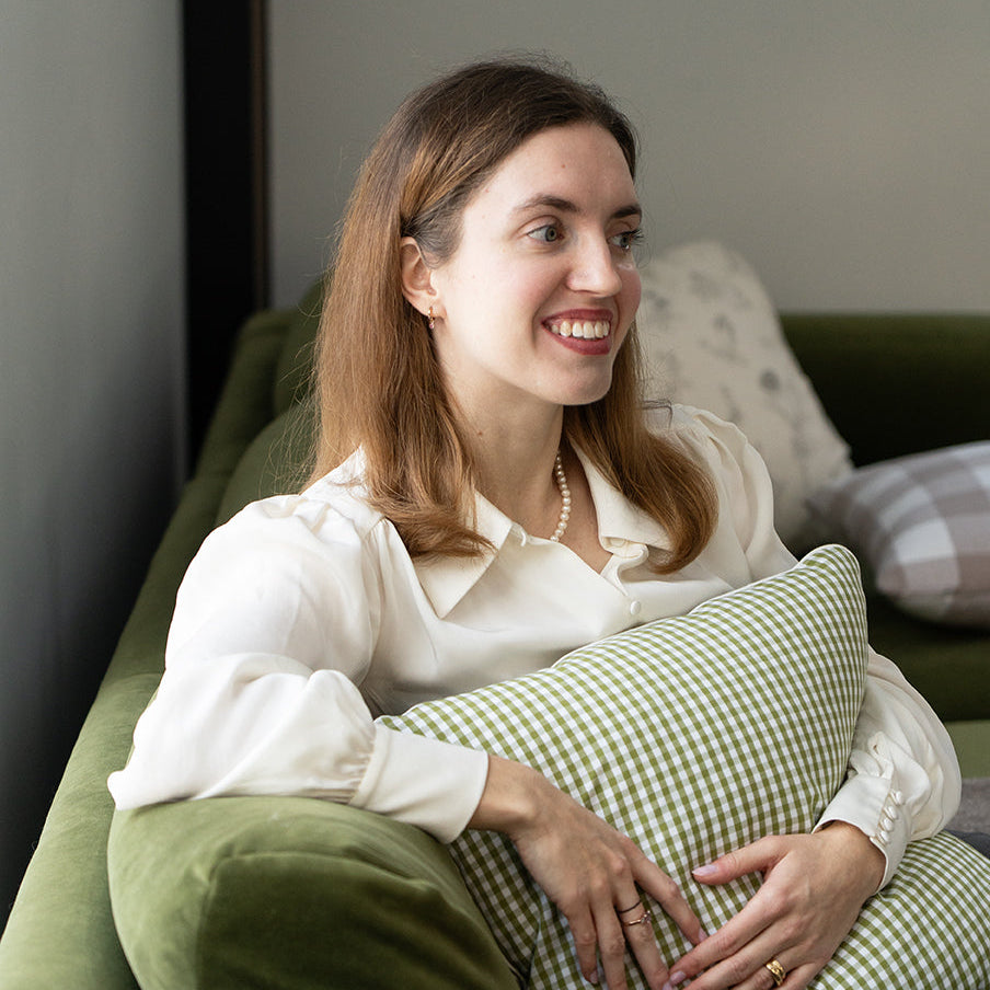 woman holding a green gingham cushion