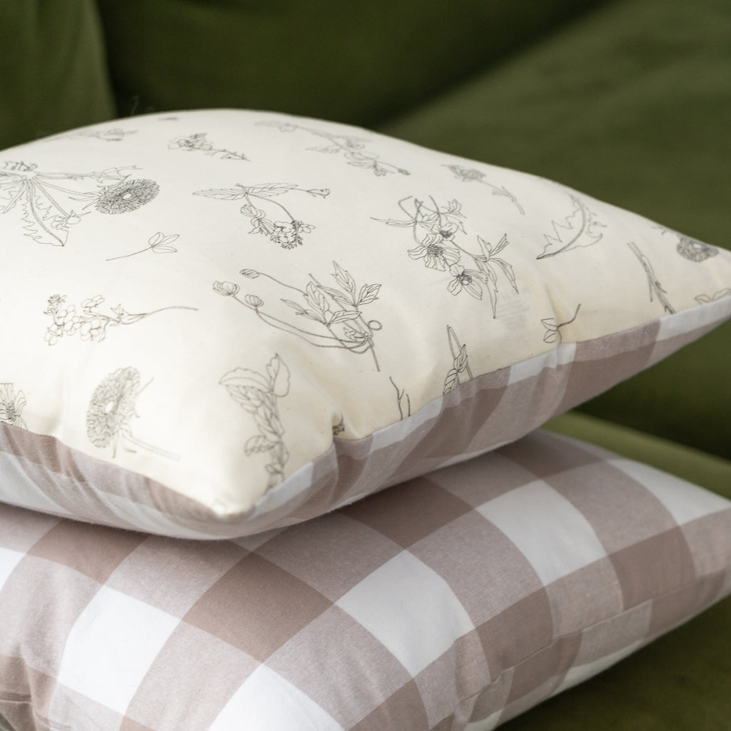 two gingham and floral cushion stacked